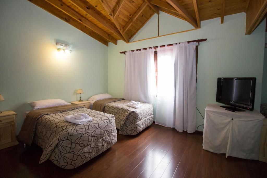 乌斯怀亚贝拉岛住宿加早餐旅馆的一间设有两张床和一台电视的房间