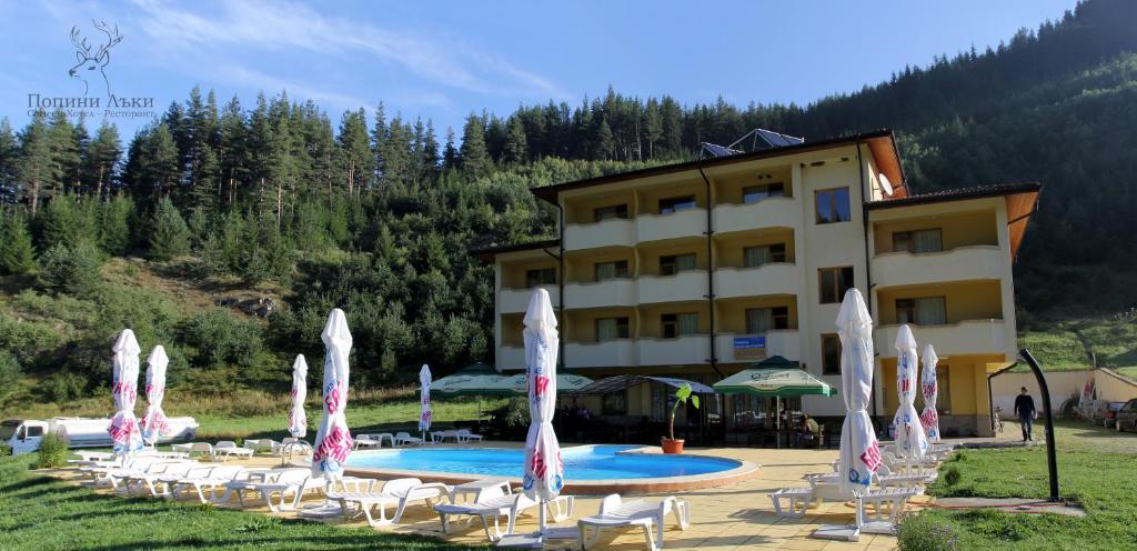 亚戈迪纳Hotel Restaurant Popini Laki的拥有一束椅子和游泳池的酒店