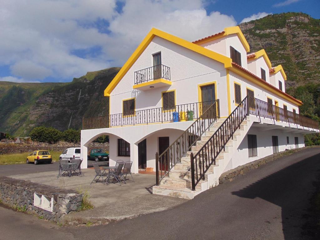 Faja GrandeCasa da Sogra的白色的房子,有黄色的屋顶和停车场