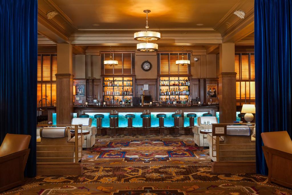 西雅图Arctic Club Hotel的一间酒吧,里面摆放着蓝色凳子