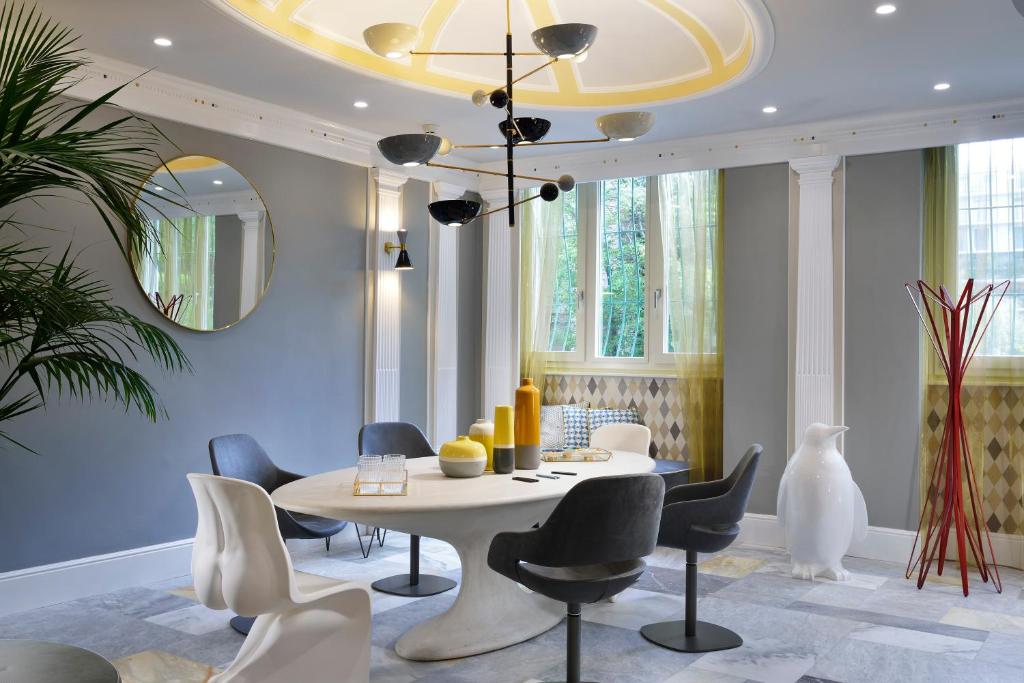 米兰黛乐西塔住宿酒店的一间配备有白色桌椅的用餐室