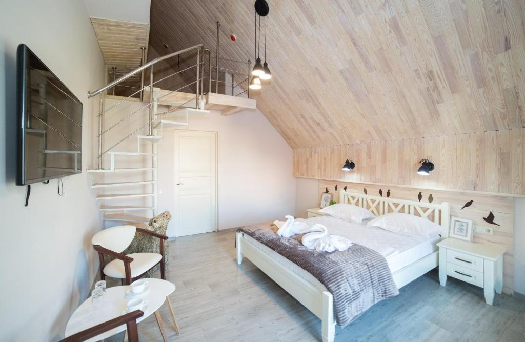 基辅米尼斯特卡湖泊度假屋的一间卧室设有一张床和木制天花板