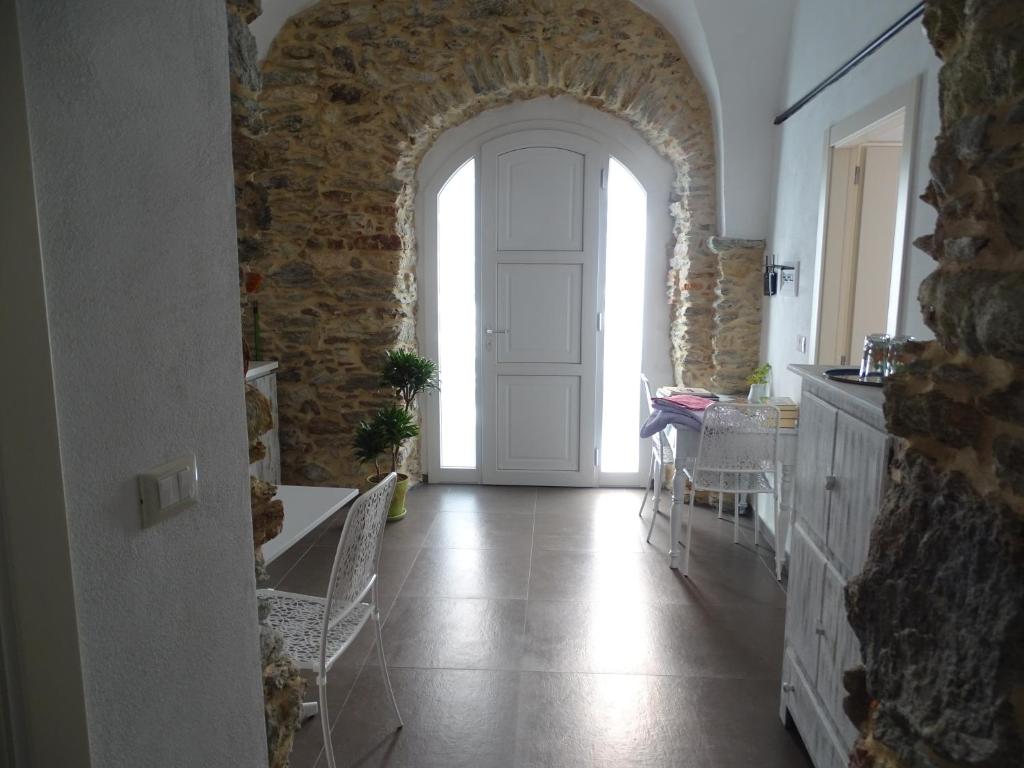CarbutaCa Du Ventu的一条带白色门和石墙的走廊