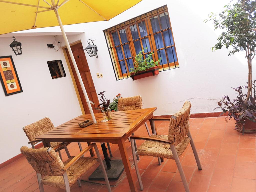 门多萨阿祖尔公寓式酒店的一张带椅子的木桌和一把伞
