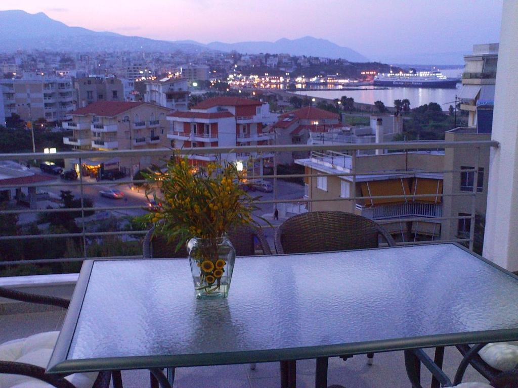 拉斐那Rafina Port Paradise的阳台上的玻璃花瓶,桌子上放着鲜花