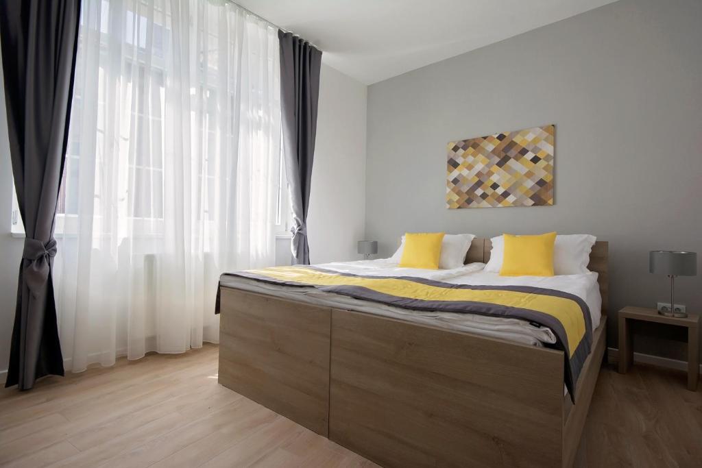 萨拉热窝享受公寓的一间卧室配有一张带黄色枕头的大床