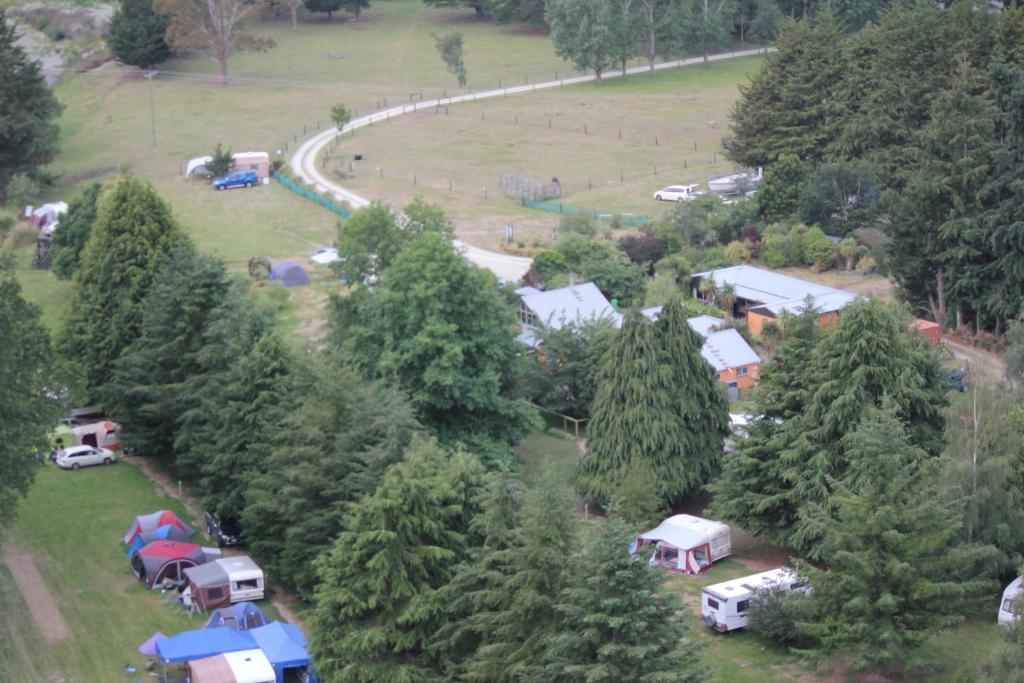 Waianakarua滨江天堂旅馆和度假公园的树木中一组帐篷的空中景观
