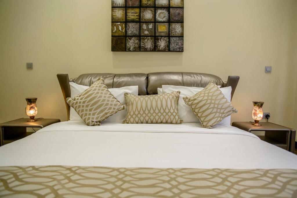 内罗毕地标套房公寓的一间卧室配有带枕头的床铺和两张桌子