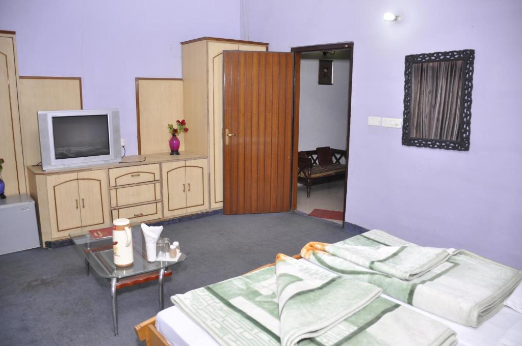 莫拉达巴德Hotel Pratiksha的客房设有1张床、1台电视和1张桌子。