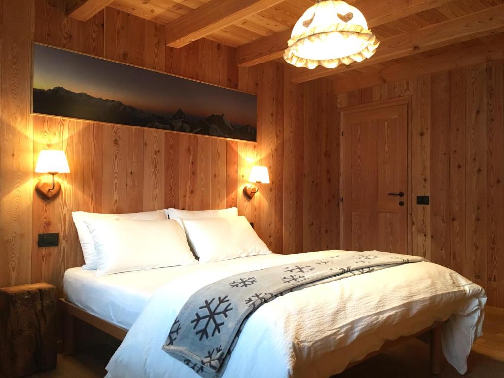 瓦托内切MaisonGorret的一间卧室配有一张床和一个吊灯