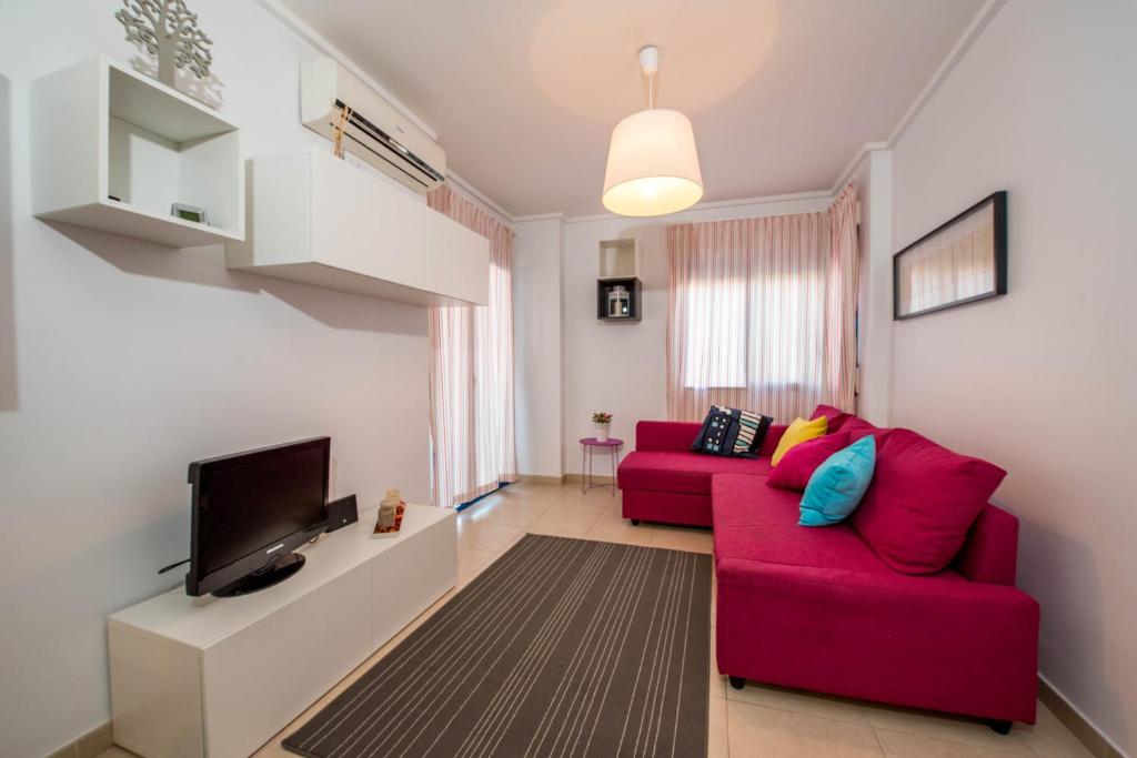阿利坎特Alicante Apartments的客厅配有红色沙发和电视