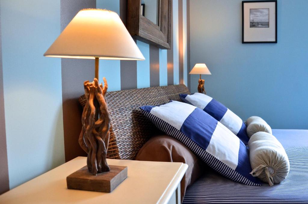 Belle-et-Houllefort佳丽别墅酒店的一间卧室配有一张床和一张桌子上的台灯