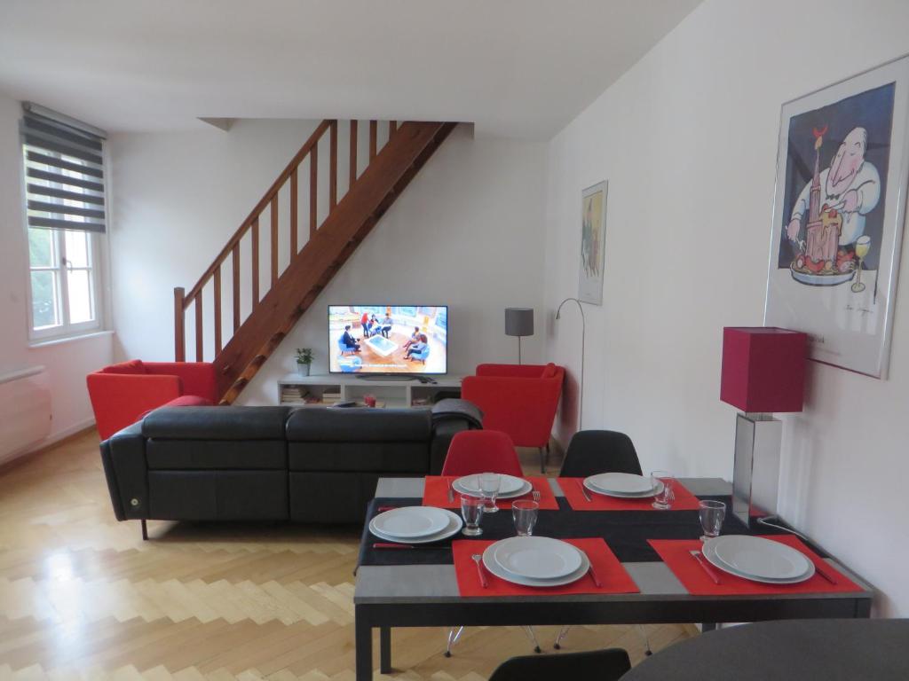 斯特拉斯堡奥奎德斯皮切尔斯公寓的客厅配有黑色沙发和红色椅子