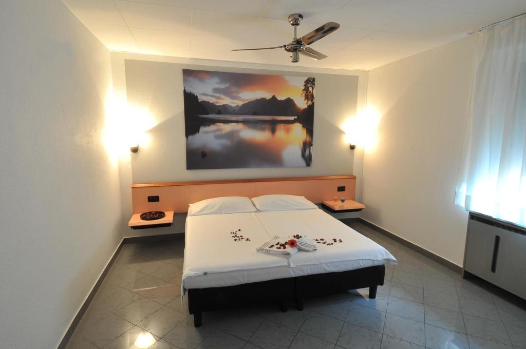 基亚索班霍夫豪斯酒店的卧室配有一张床,墙上挂有绘画作品