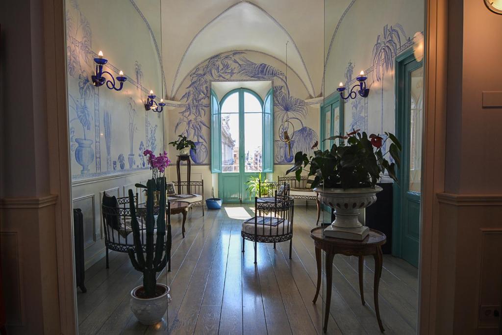 罗马Lilium Boutique Hotel的走廊上设有椅子,墙上装饰有绘画作品。
