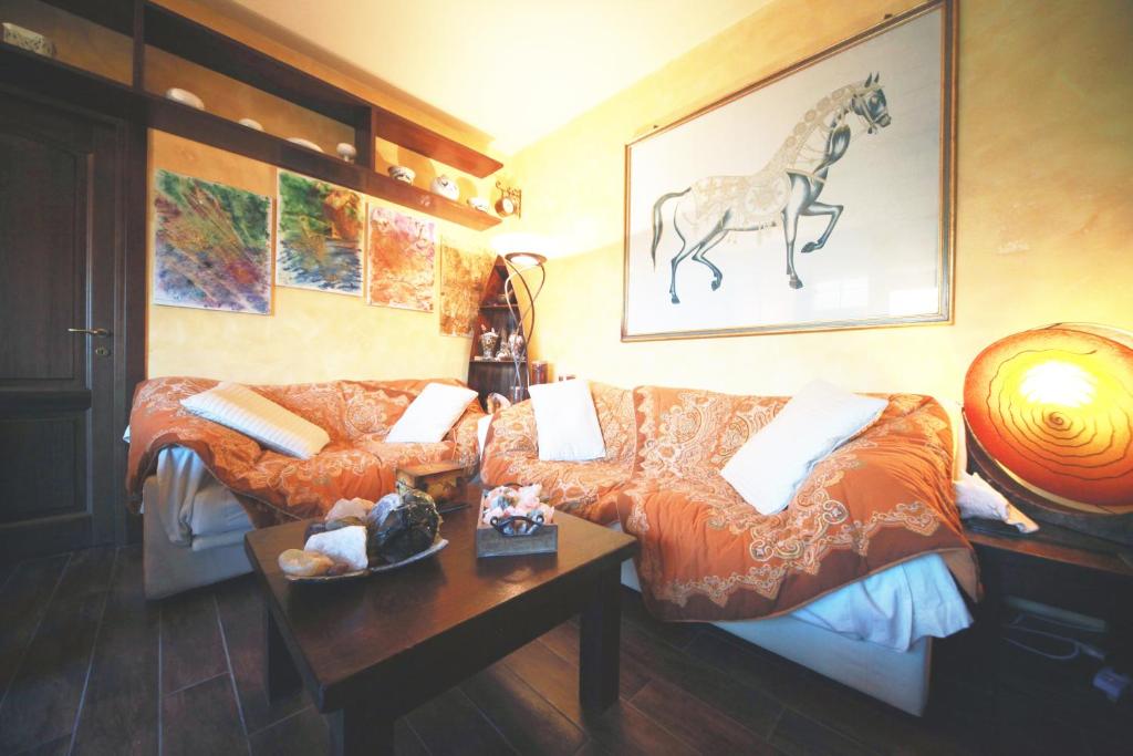 米兰Bed & Breakfast A San Siro 75的客厅配有沙发,墙上有马匹