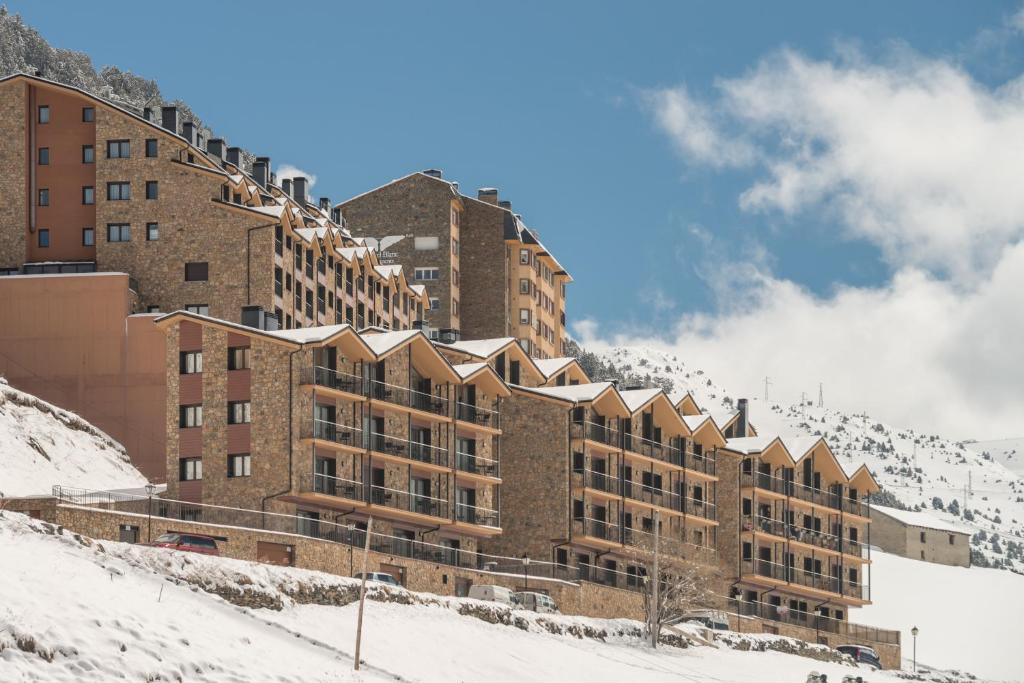 博尔德斯·代瓦里拉皮埃尔&法坎斯安道尔博尔德恩法力拉酒店的一座大建筑,位于一座白雪覆盖的山顶上