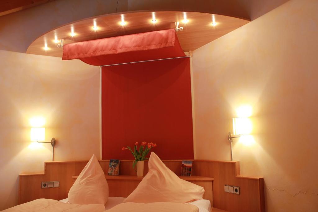 凯撒斯劳滕福利池酒店及餐厅的一间卧室配有床和红色的灯光墙