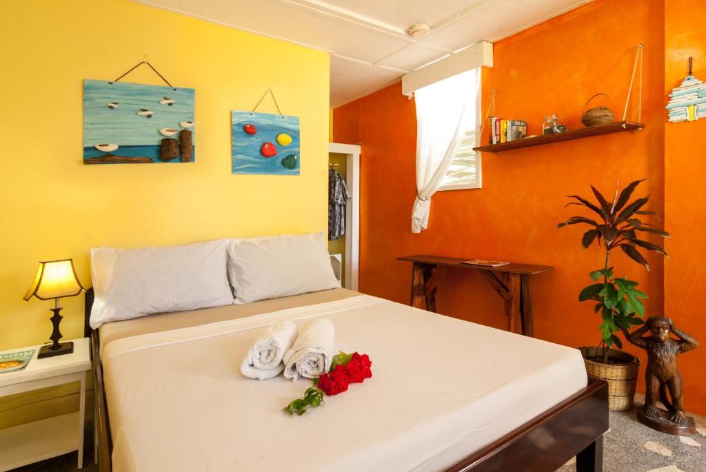 曼巴豪库尔马生态海滩度假村的一间卧室配有带毛巾和鲜花的床