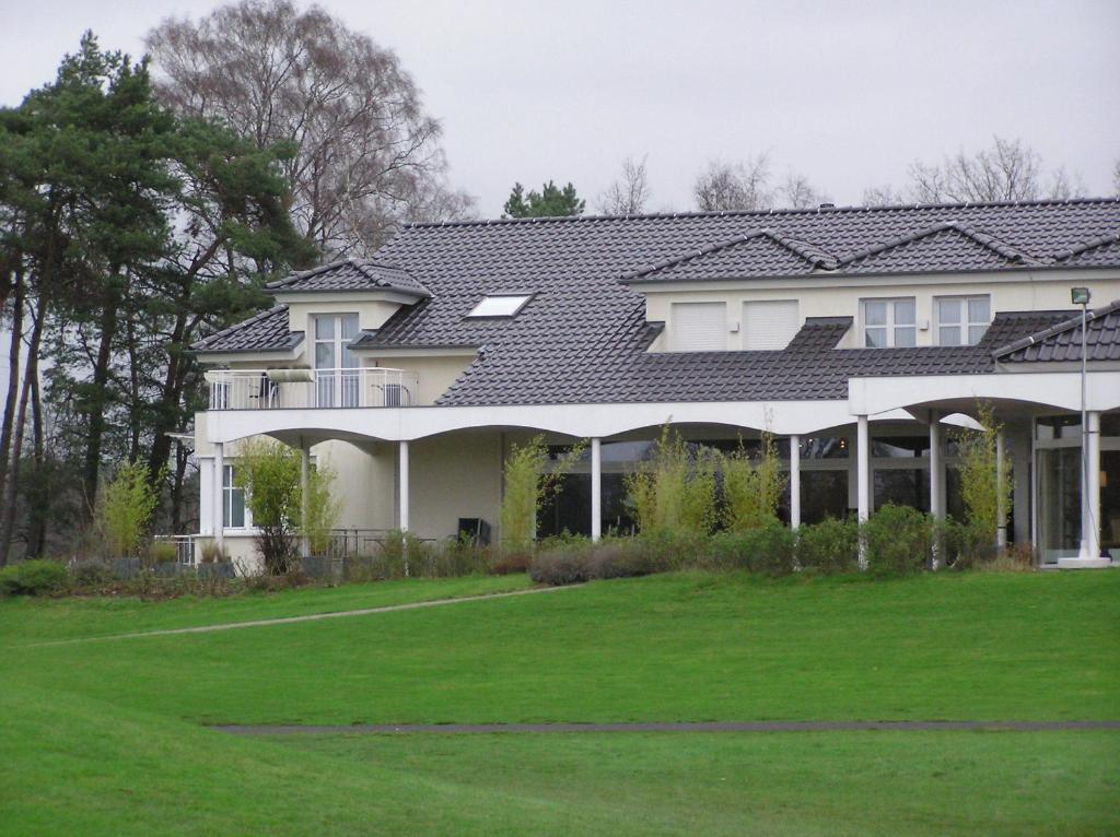 赖讷莱茵博物馆高尔夫酒店的前面有绿色草坪的房子