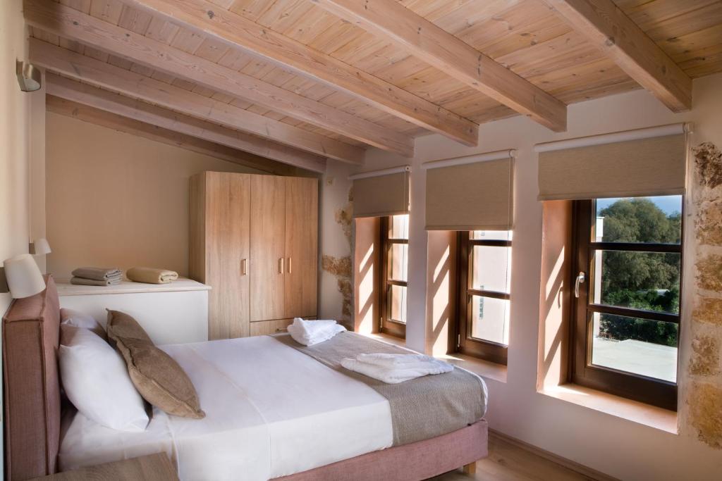 干尼亚C&M Residence Chania Old Town的一间卧室设有一张床和两个窗户。