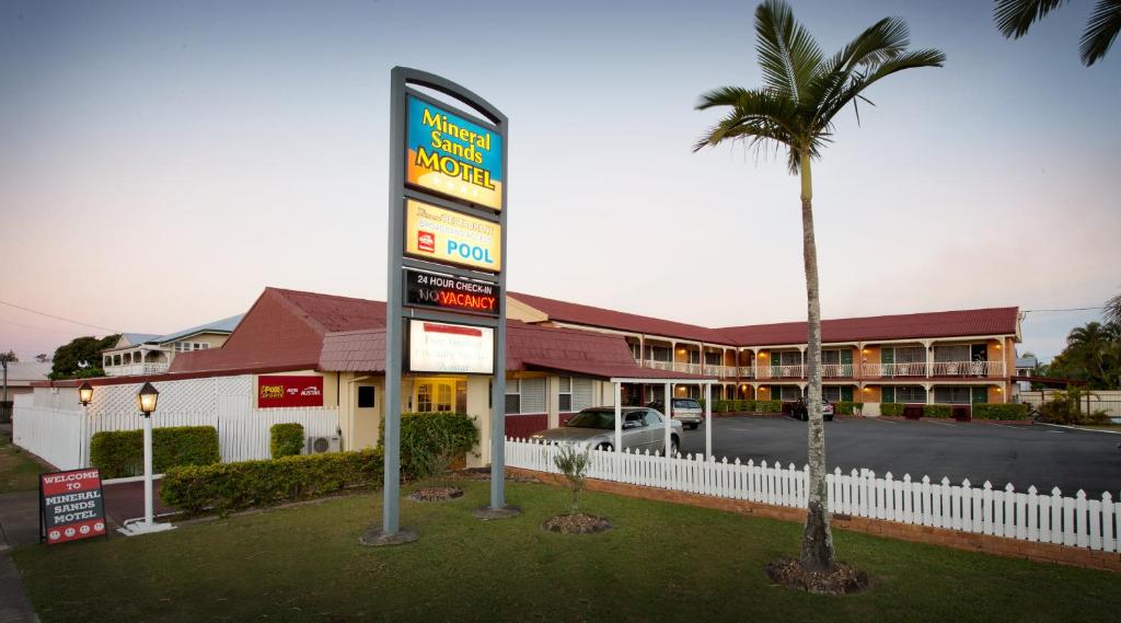 玛丽伯勒矿物金沙汽车旅馆 的棕榈树建筑前的汽车旅馆标志