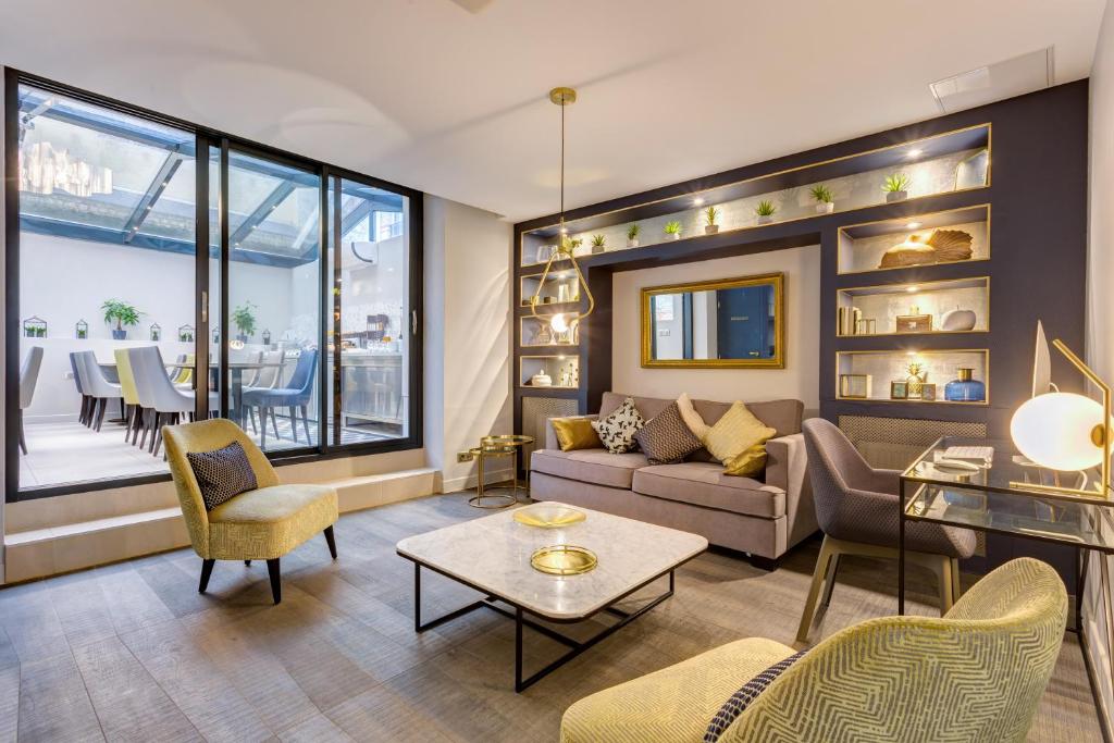 巴黎维利尔花园酒店的客厅配有沙发、椅子和桌子