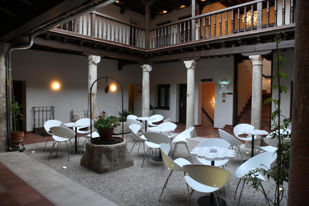 阿尔卡拉德荷那利斯伊万尼亚阿尔卡拉精品酒店的大楼内带白色桌椅的庭院