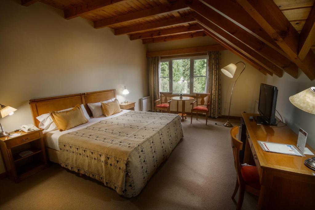 埃尔卡拉法特克斯坦艾克酒店的一间卧室配有一张床、一张书桌和一台电视