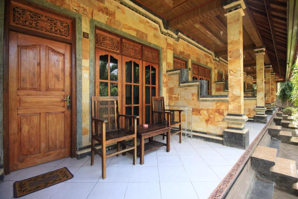 蓝梦岛捷鹏巴厘岛别墅 的门廊上设有木门和椅子的房子