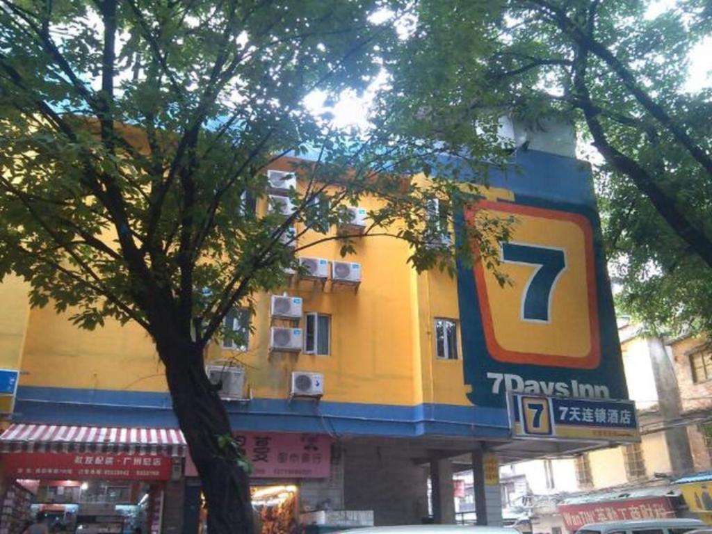 广州7天连锁酒店广州北京路地铁站店的一座黄色的大建筑,上面有标志
