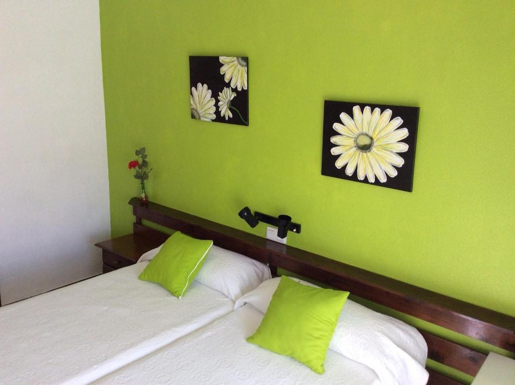 圣地亚哥德拉里贝拉K-西托旅馆的一间卧室设有两张带绿色墙壁的床