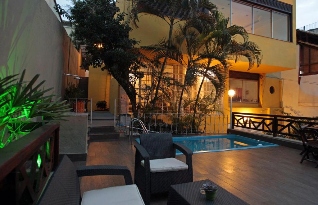里约热内卢Hangar Rio Hostel的酒店庭院设有游泳池和棕榈树