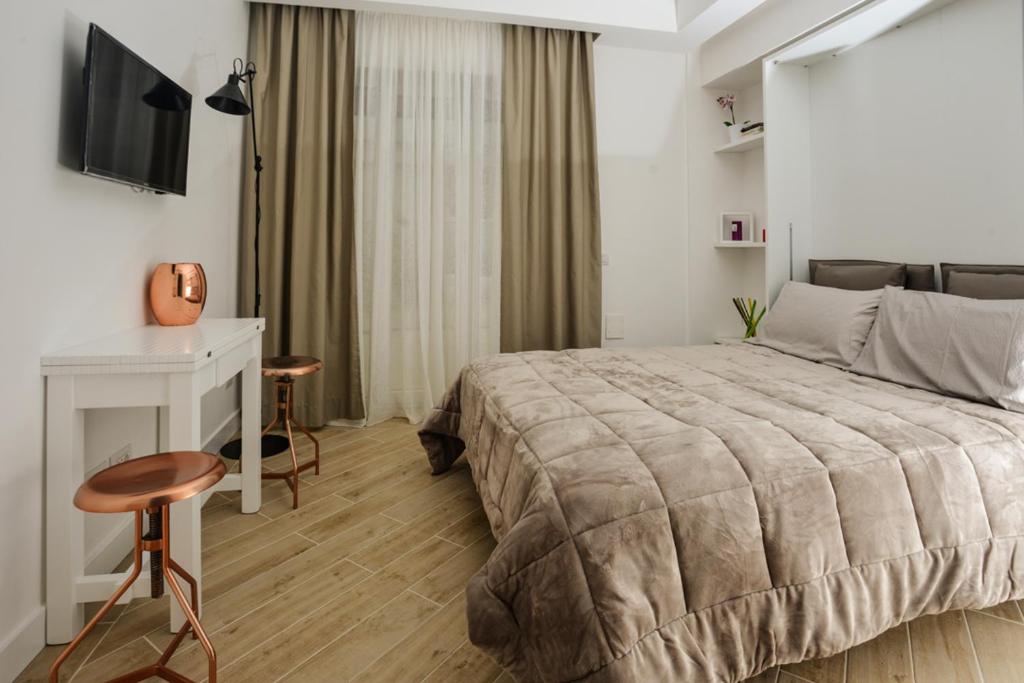 那不勒斯Click&Sleep Fuorigrotta的一间卧室配有一张床、一张书桌和一台电视