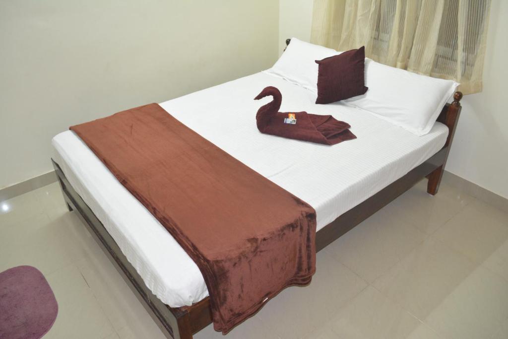 马伊拉杜图赖JP Nivaas Guest House的一间卧室配有一张带天鹅的床
