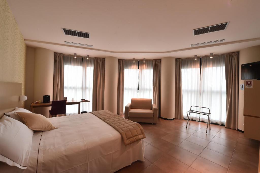 卢戈塔蒂酒店的酒店客房带一张床、椅子和窗户