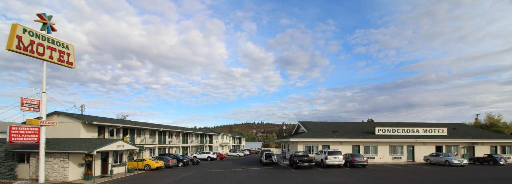 GoldendalePonderosa Motel汽车旅馆的汽车停泊在停车场的汽车旅馆