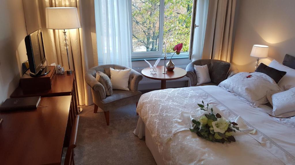 波杰布拉迪Solitaire的酒店客房设有床、桌子和窗户。