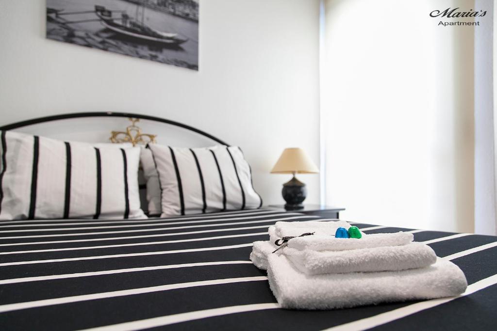 波尔图Maria's Apartment的一间卧室配有带毛巾的床