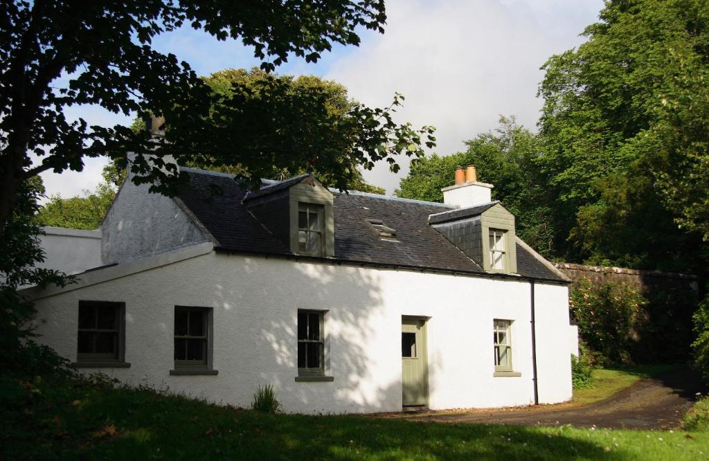邓韦根Dunvegan Castle Rose Valley Cottage的黑色屋顶的白色房子