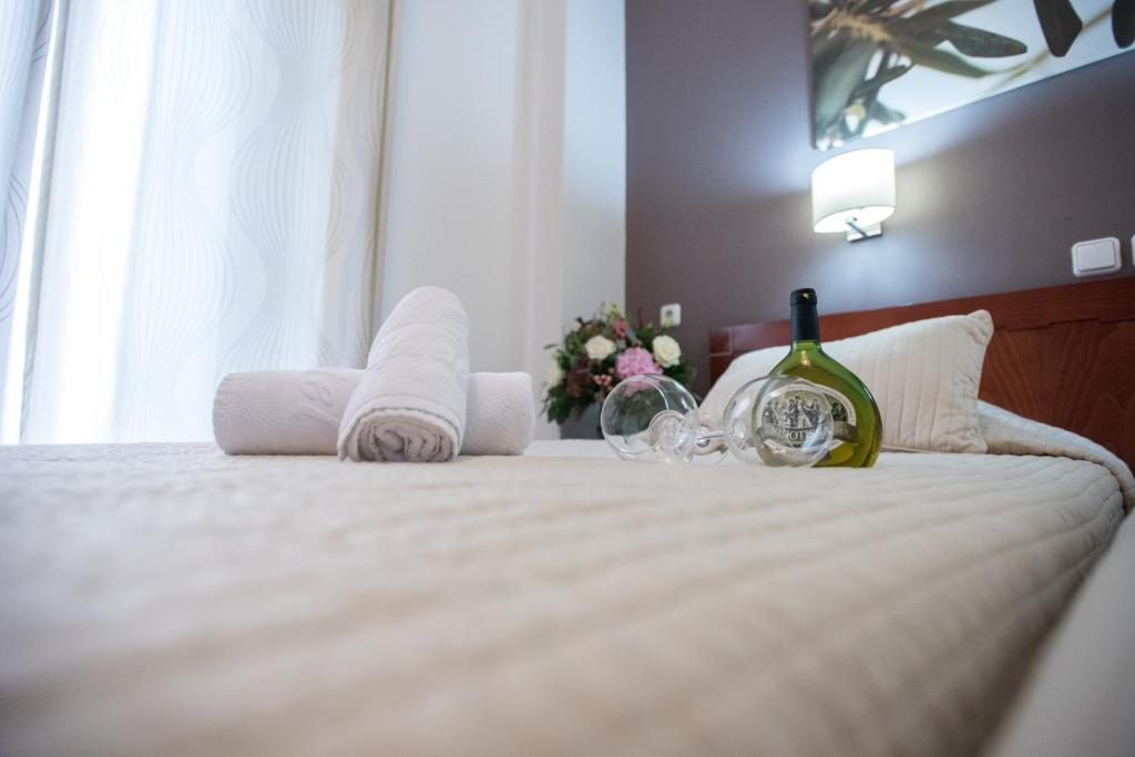 雅典艾皮达弗罗斯酒店的一间卧室配有一张带毛巾和一瓶葡萄酒的床。