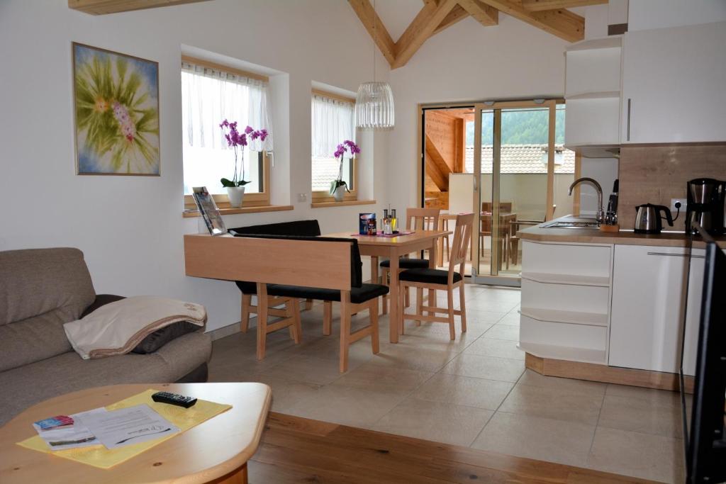 圣马蒂诺Privatpension Bergkristall的厨房以及带沙发和桌子的客厅。