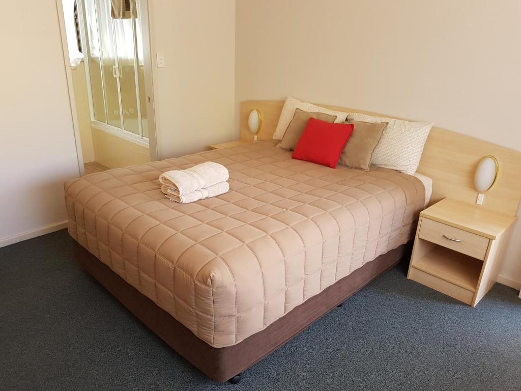 尼尔森湾Central Motel Nelson Bay的一张床上的床上红色枕头