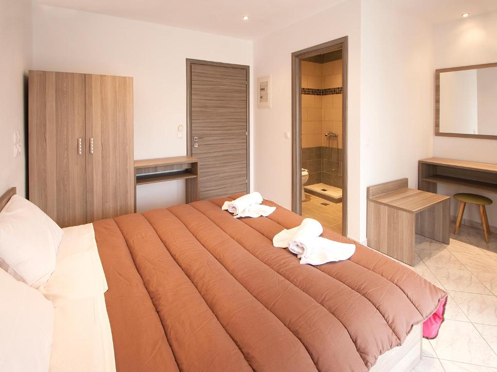 斯基亚索斯镇PINEAPPLE Skiathos的一间卧室配有一张大床和两条毛巾