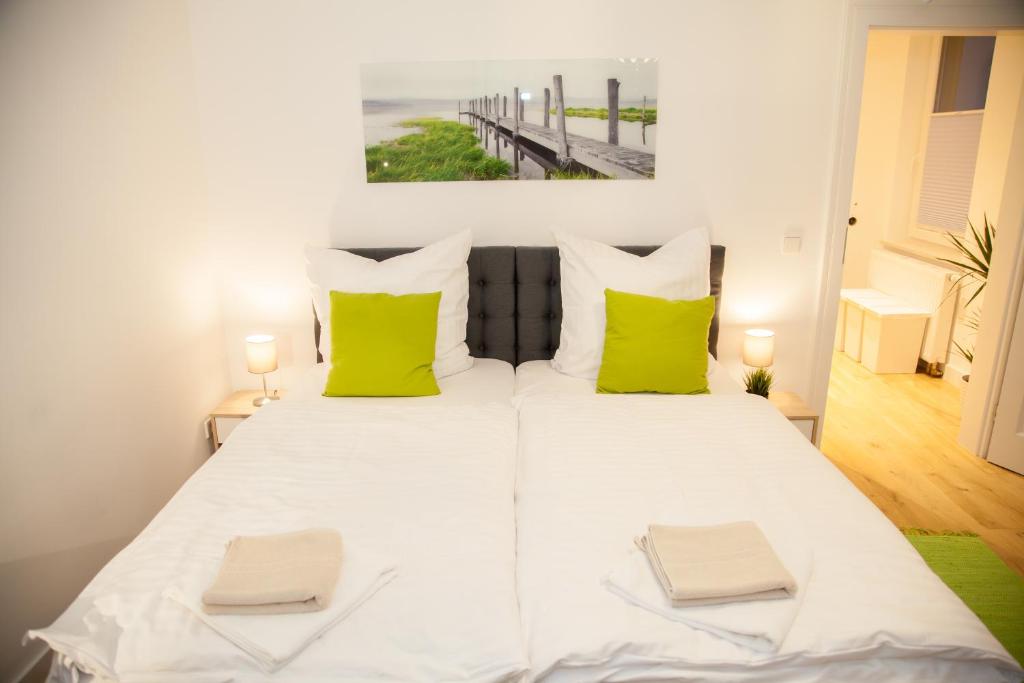海德堡海德堡公寓的卧室配有带绿色枕头的大型白色床