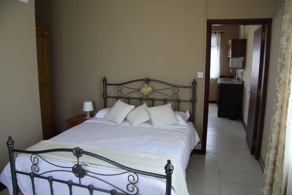 康隆尼角Les Trois Fleurs的一间卧室配有带白色床单和枕头的床。