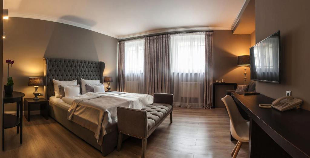 比尔森兰阁酒店的一间卧室配有一张床、一张书桌和一个窗户。