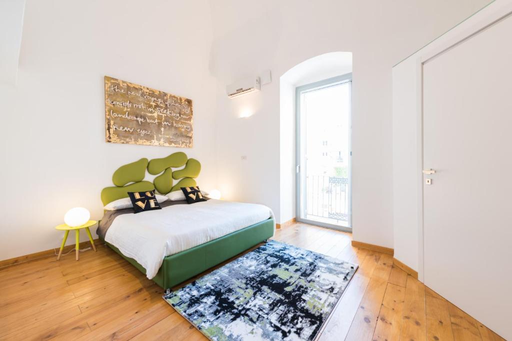 巴里巴里市中心艺术阁楼M8公寓的一间卧室配有一张床和地毯