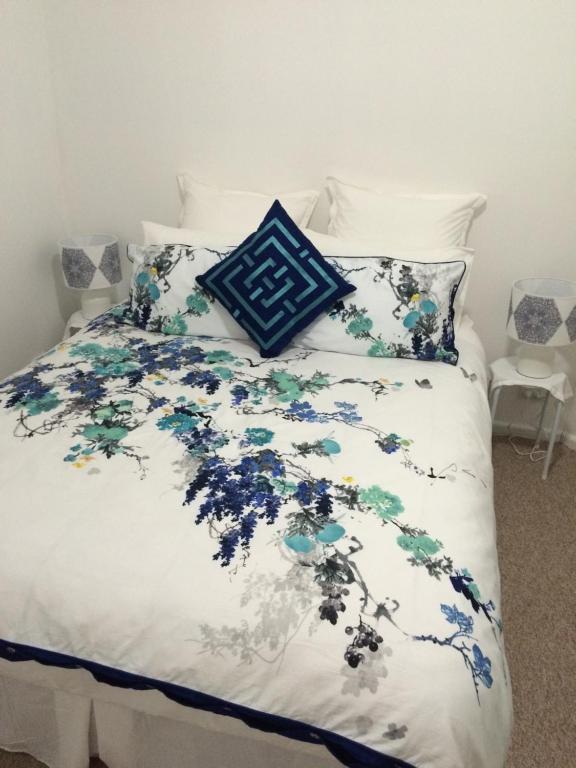 库纳巴拉布兰兰利小屋住宿加早餐旅馆的一张带蓝色和白色棉被和枕头的床