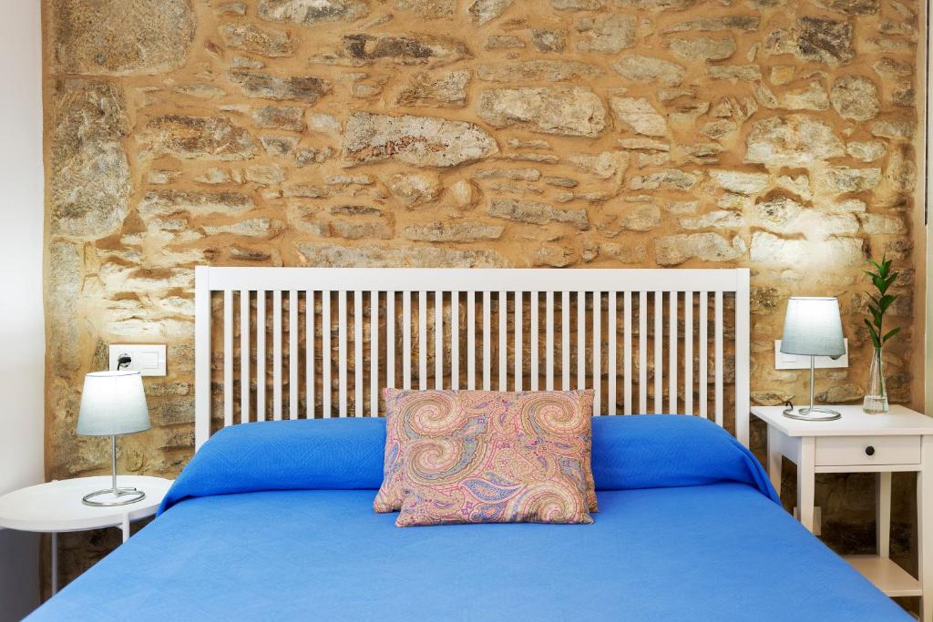 圣地亚哥－德孔波斯特拉Pensión Rua Nova的一间卧室配有蓝色的床和2个床头柜